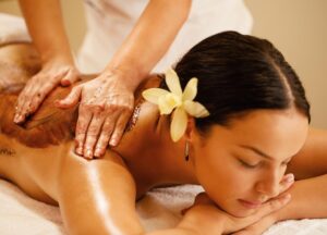 A woman is enjoying body scrub.