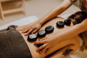 A woman is enjoying hot stones massage.