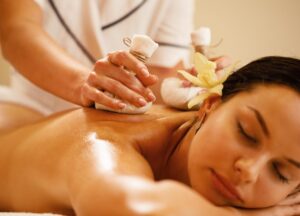 A woman is enjoying herbal massage.