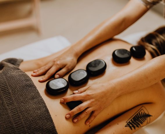 A woman is enjoying hot stones massage.