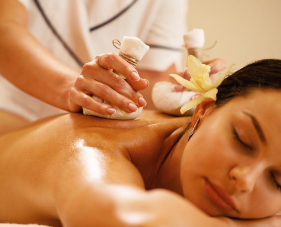 A woman is enjoying herbal massage.